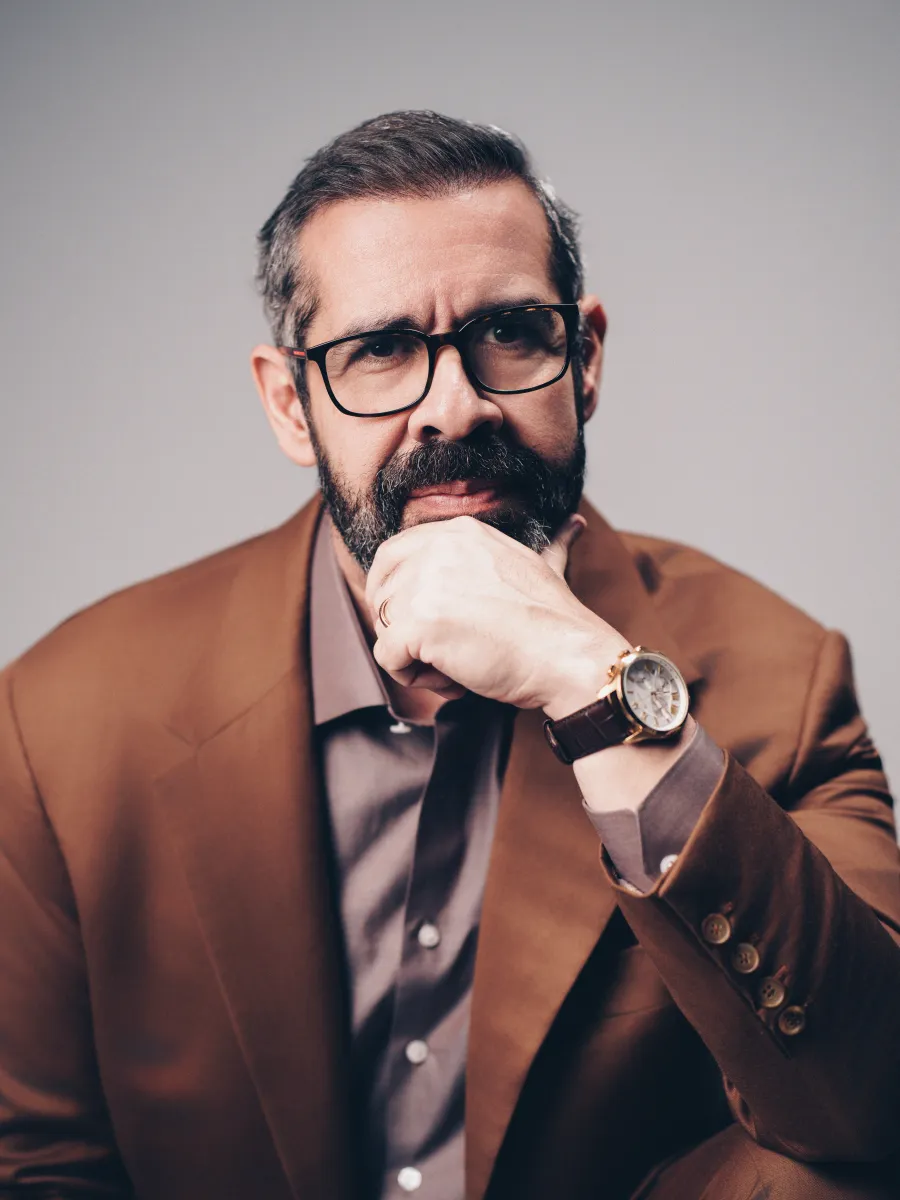 Dr. Paulo Porto de Melo com a mão apoiada no queixo.