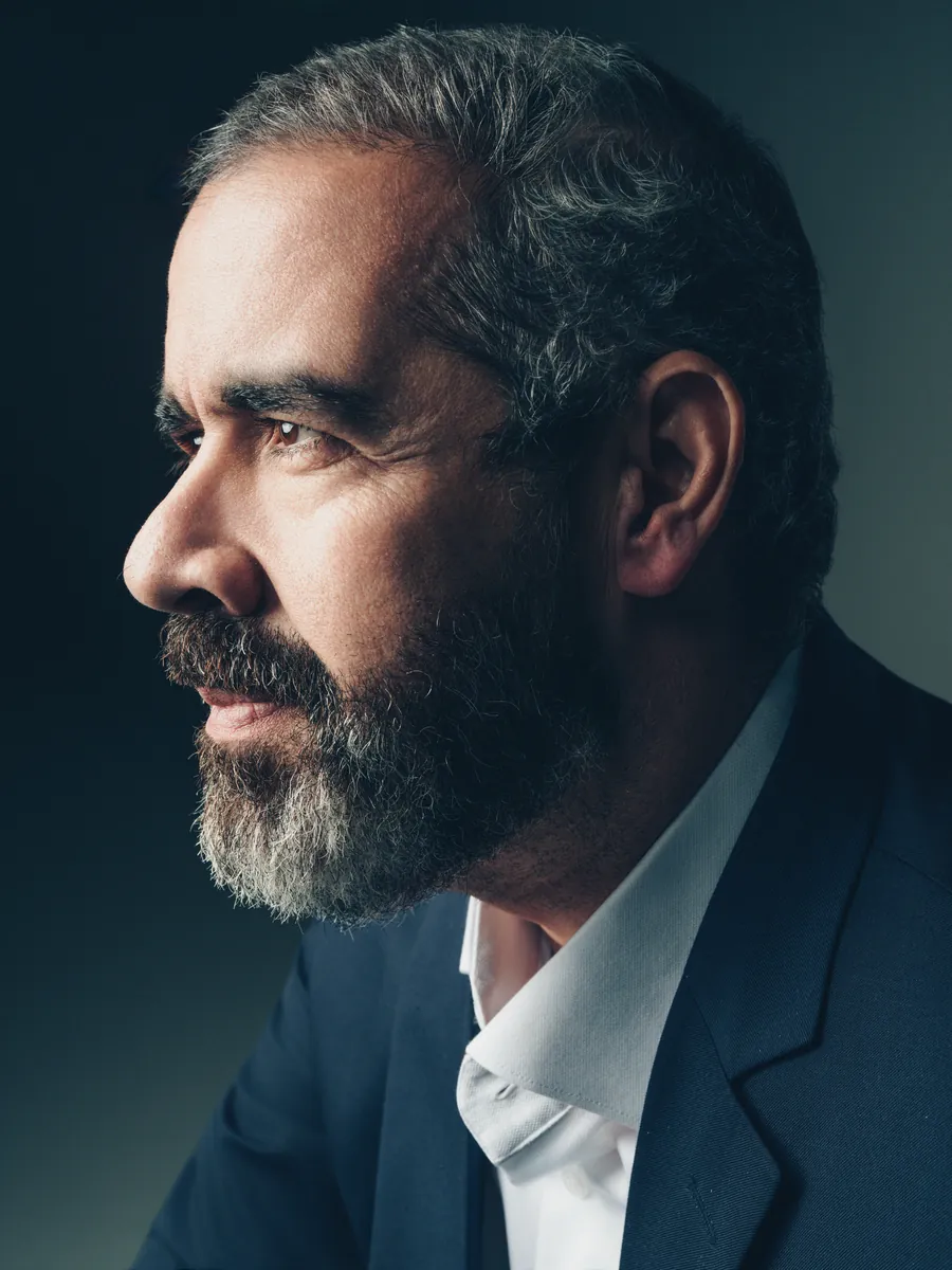 Retrato de perfil do Dr. Paulo Porto de Melo em fundo escuro.